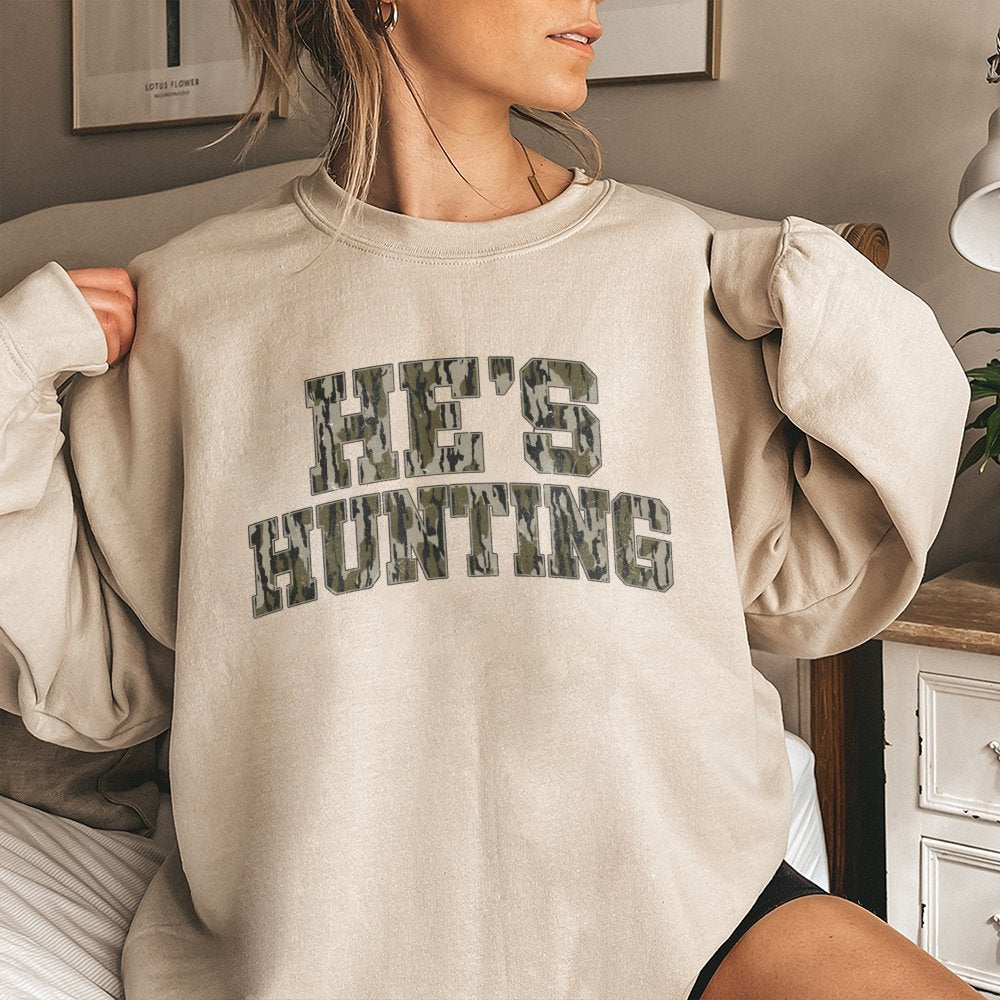 He's Hunting Sweatshirt | Camo Collegiate Lettering Design | Premium Cotton-Poly Blend | Gift for Deer Hunters and Outdoorsme